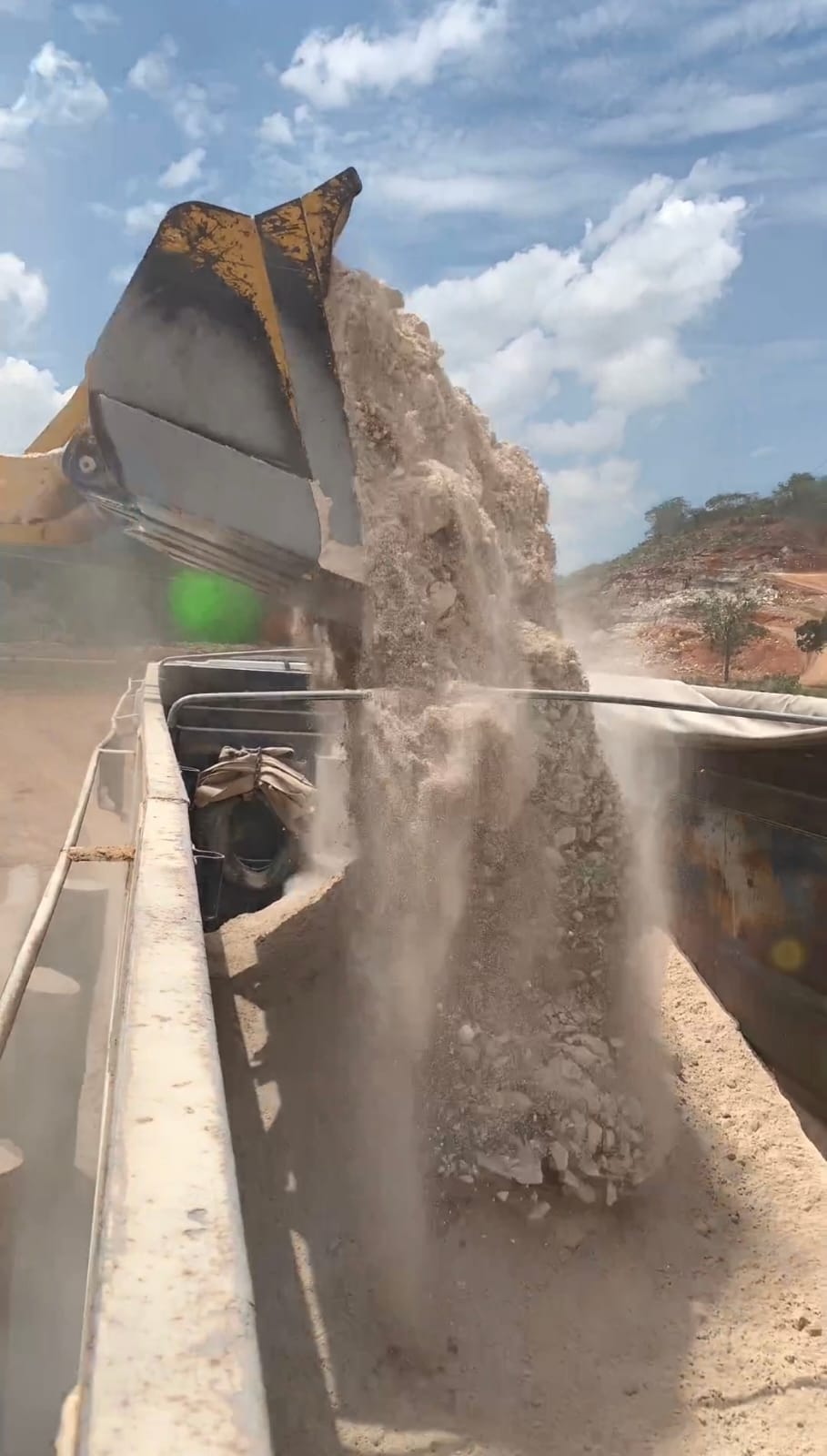 Pá carregadeira despejando material no caminhão na LIDERCAL